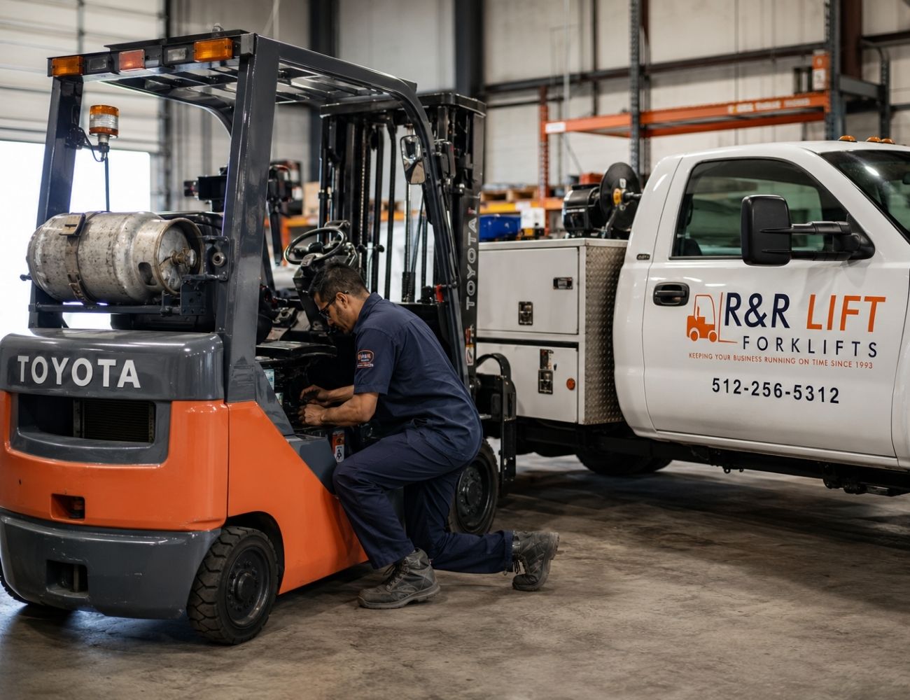 Toyota forklift being serviced by an R&R Lift technician beside a branded service truck inside a warehouse