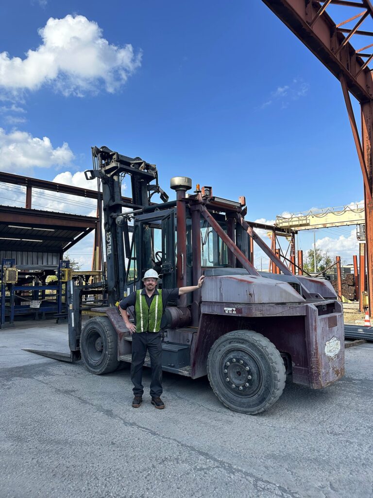 Fleet manager reviewing OSHA forklift maintenance documentation with a technician inside an industrial warehouse