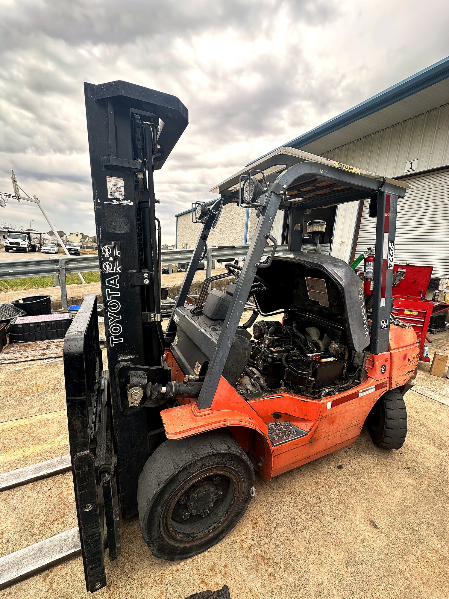 Forklift operator completing a pre-shift inspection checklist before using warehouse equipment.