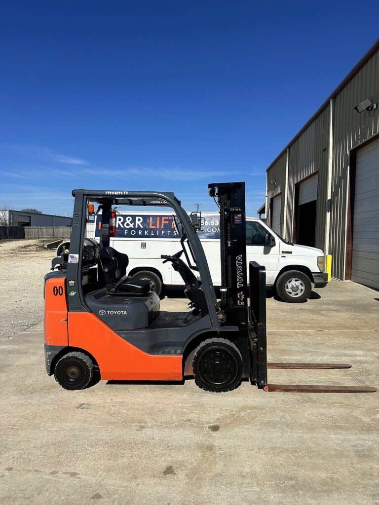 Warehouse forklift service evaluation scene showing a technician, fleet manager, and maintenance report during a vendor review