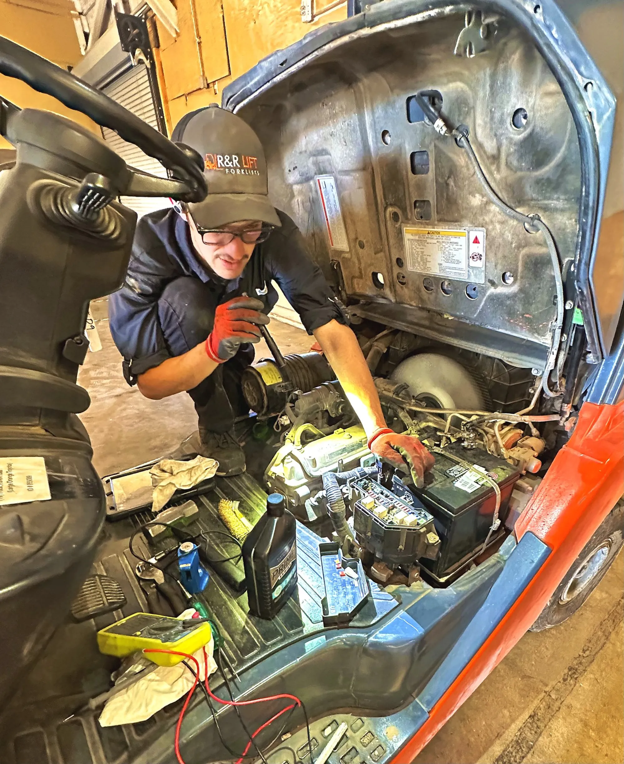 R&R Lift technician working on a forklift engine