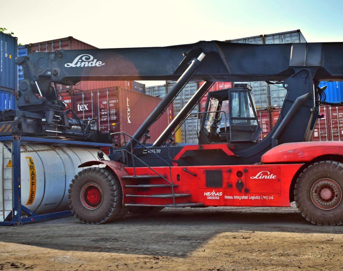 Forklift operating at a cargo yard, moving large containers efficiently.