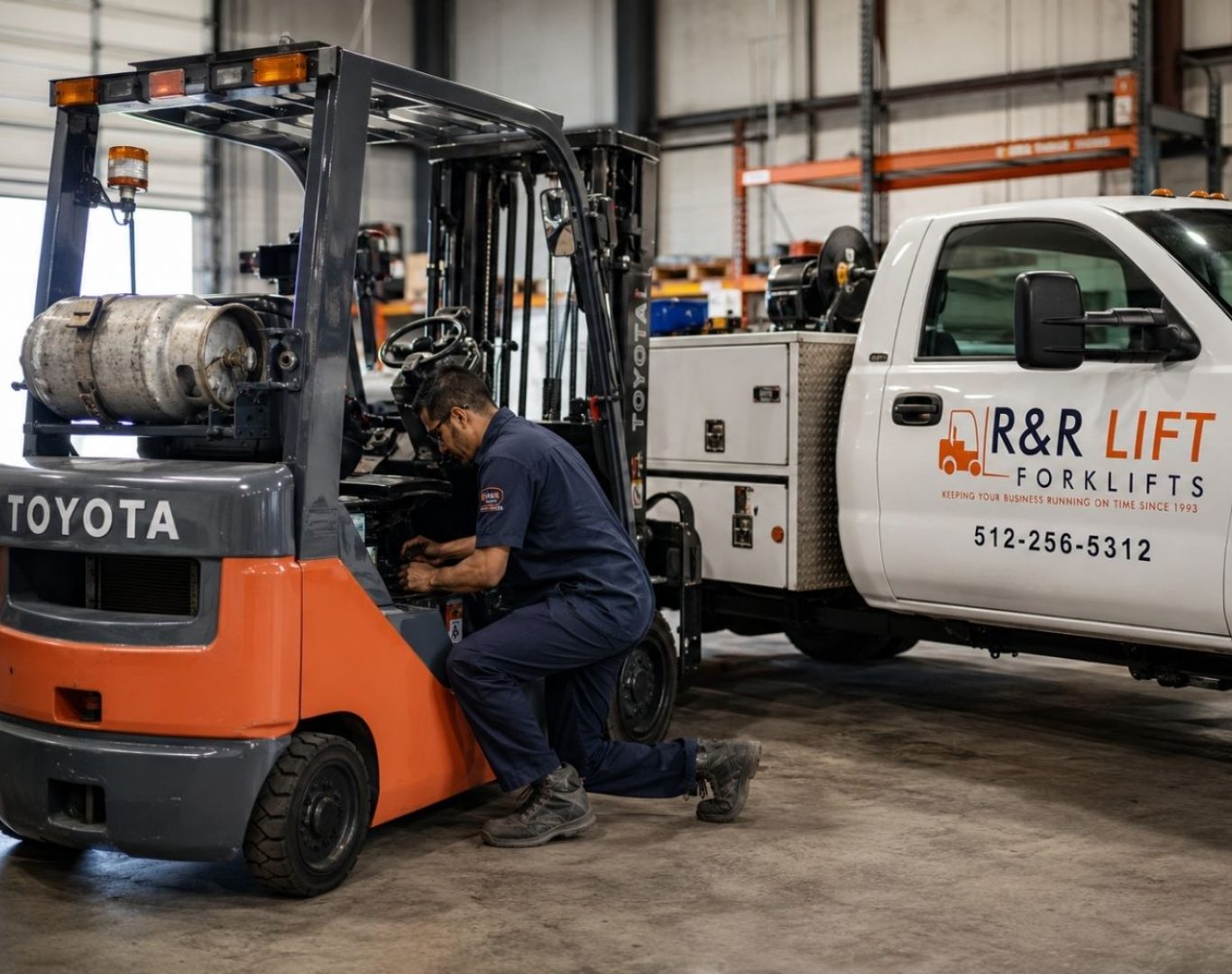 Toyota forklift being serviced by an R&R Lift technician beside a branded service truck inside a warehouse